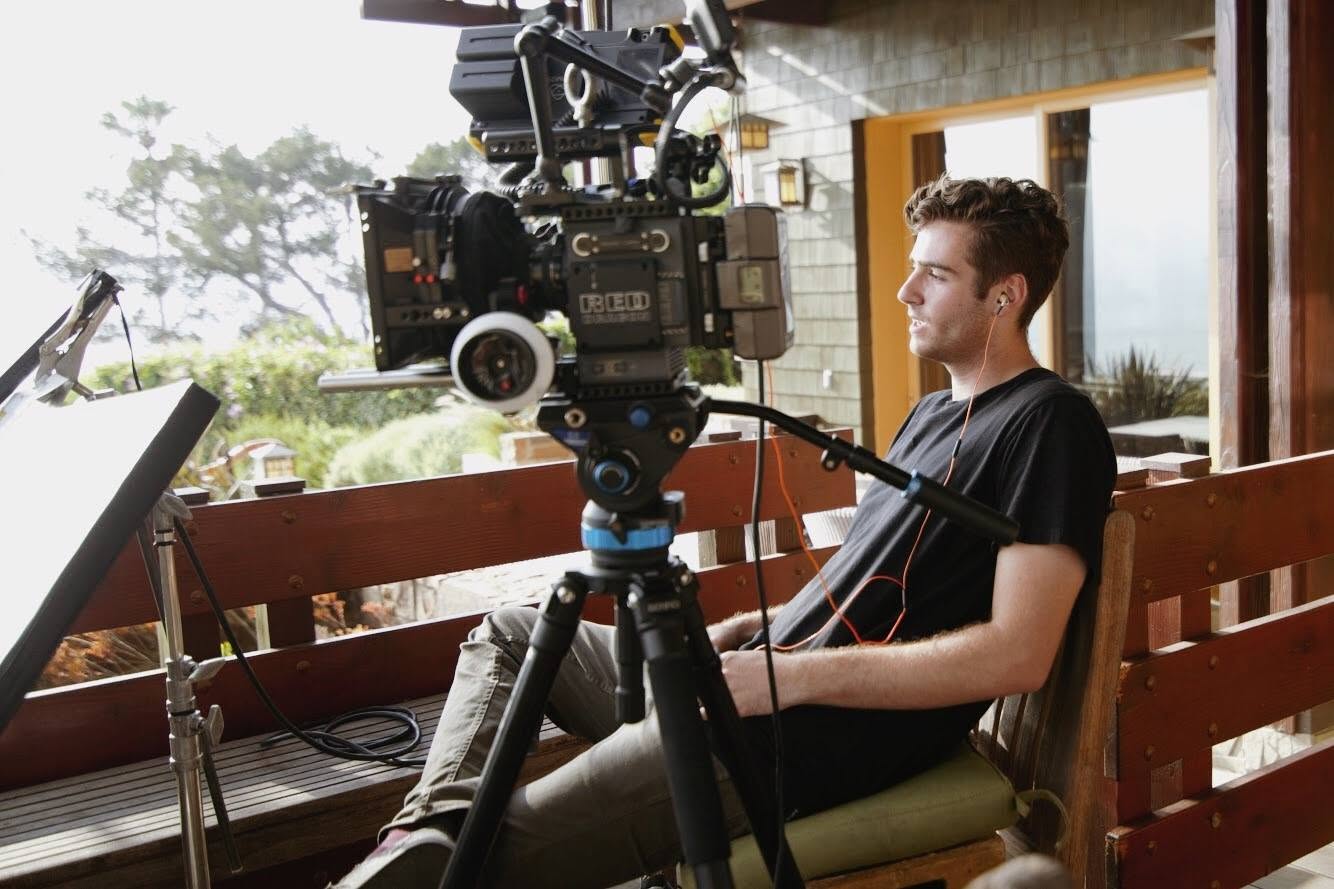 Adam Linssen reviewing a shot beside a RED cinema camera