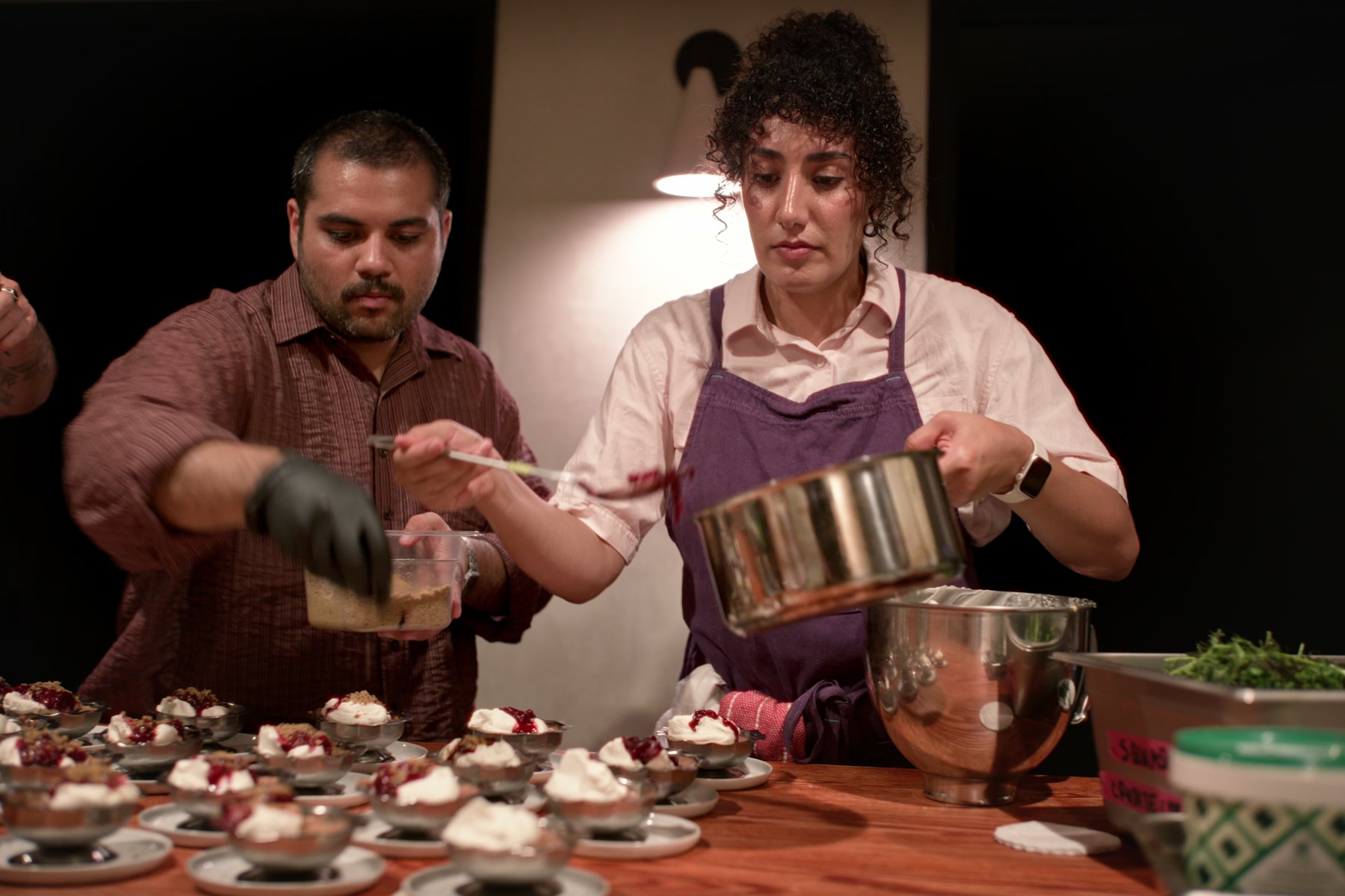 Chefs finishing dozens of dessert plates