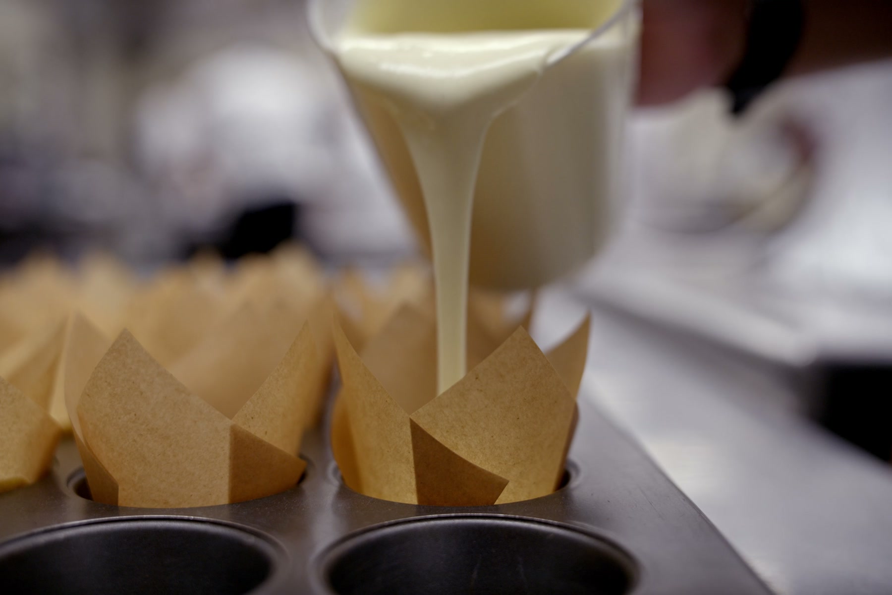 Batter being poured into baking cups in the Kitchens for Good kitchen
