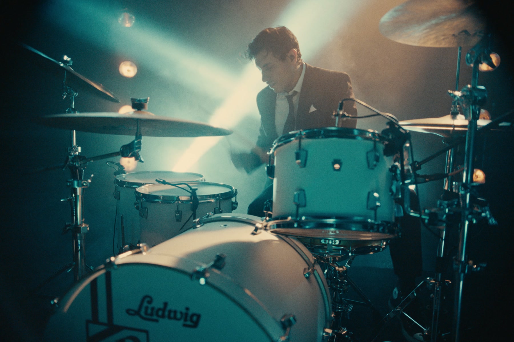 A Ludwig drummer surrounded by teal and amber stage light